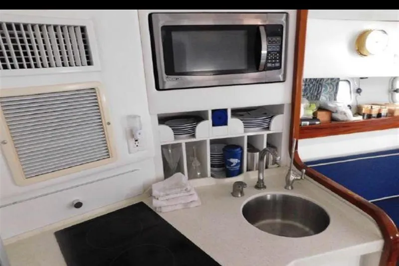 Slide: The Image of Compact kitchen area in a 1988 Magnum 40 Sport boat with microwave and sink. - 24