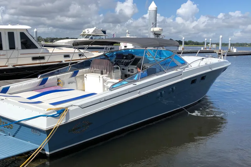 Slide: The Image of 1988 Magnum 40 Sport boat docked at marina under cloudy sky. - 4