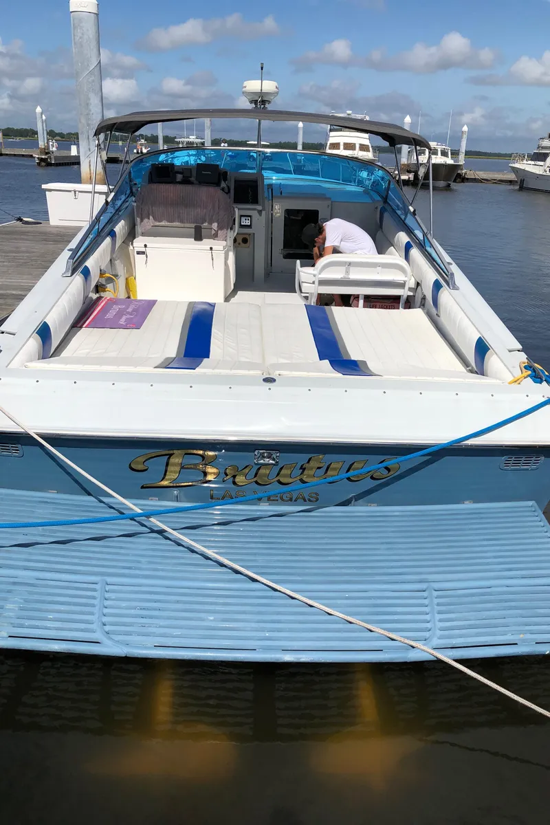 Slide: The Image of 1988 Magnum 40 Sport boat docked, featuring blue and white design with "Brutus" lettering. - 7