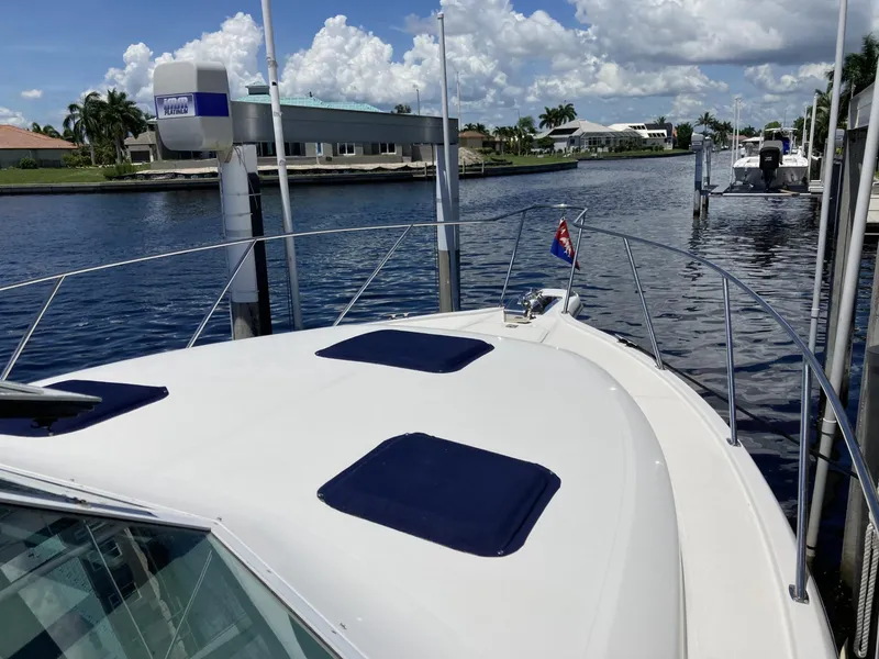 Slide: The Image of 2000 Tiara Yachts 3100 Open docked by a scenic waterfront. - 11