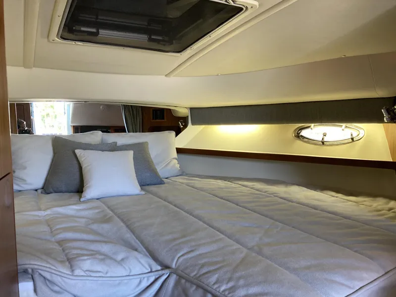 Slide: The Image of Cozy cabin interior of 2000 Tiara Yachts 3100 Open with plush bedding and porthole. - 18
