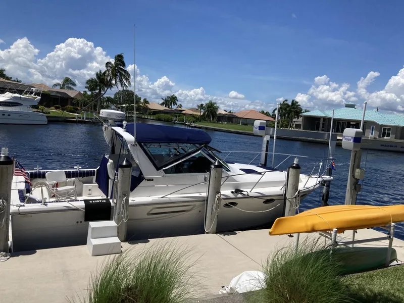 Slide: The Image of 2000 Tiara Yachts 3100 Open docked by a canal under a clear blue sky. - 2