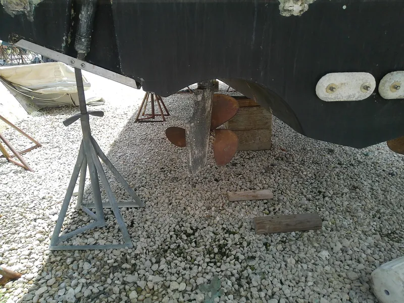 Slide: The Image of 2000 Tiara Yachts 3100 Open propeller and hull on gravel with support stands. - 23