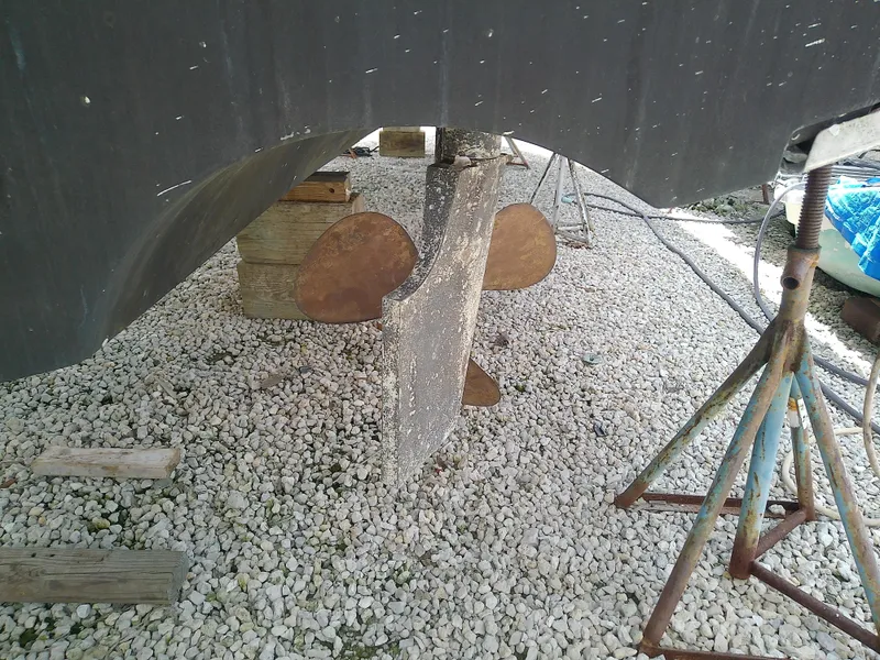 Slide: The Image of Propeller and rudder of a 2000 Tiara Yachts 3100 Open on gravel. - 24