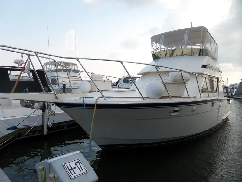 The Image of 1987 Hatteras 42 Convertible yacht docked at marina, side view. - 1