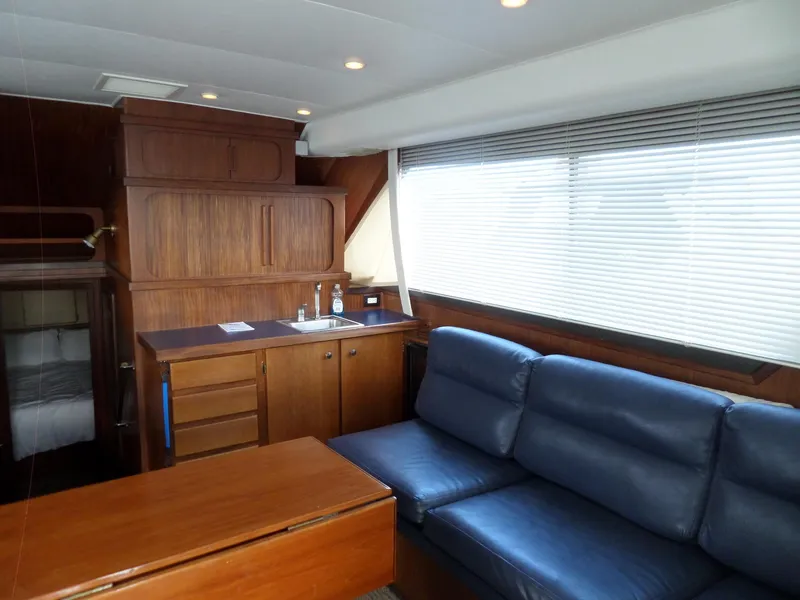 Slide: The Image of Interior of 1987 Hatteras 42 Convertible yacht with blue sofa and wooden cabinetry. - 15