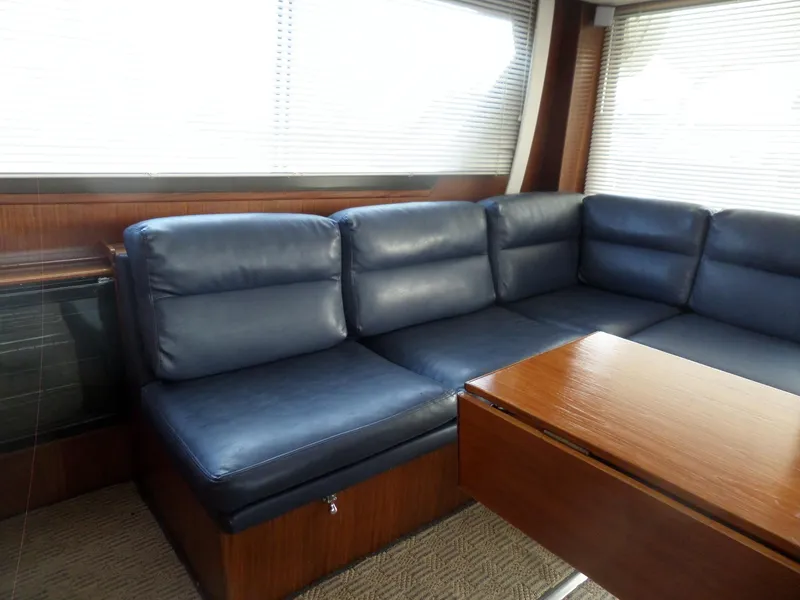 Slide: The Image of Interior of 1987 Hatteras 42 Convertible yacht with blue leather seating and wooden table. - 18
