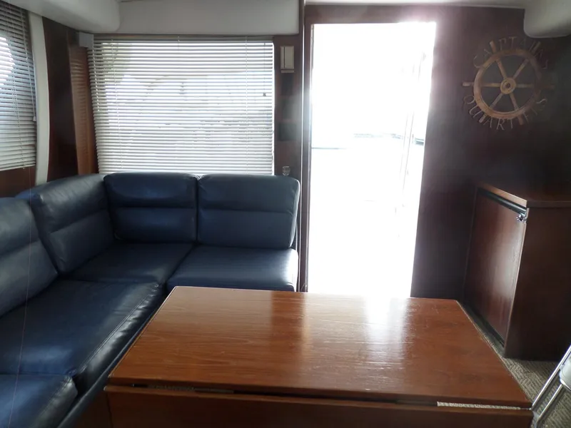 Slide: The Image of Interior of 1987 Hatteras 42 Convertible yacht with blue leather seating and wooden table. - 19