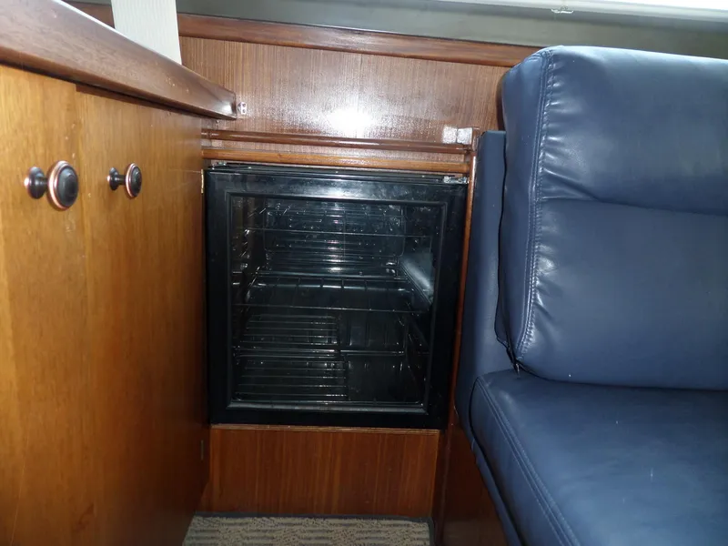 Slide: The Image of Interior of 1987 Hatteras 42 Convertible with wood cabinetry and blue leather seating. - 23