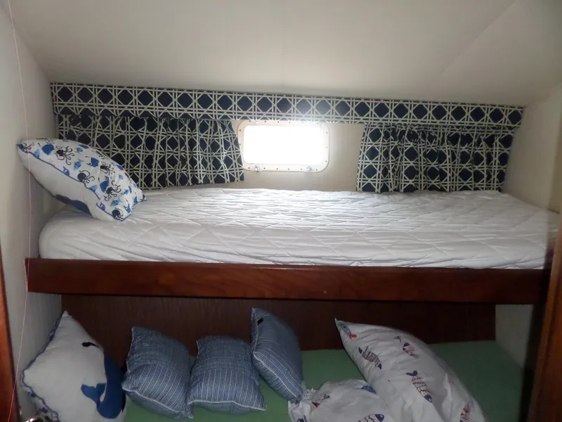 Slide: The Image of Interior of 1987 Hatteras 42 Convertible with bunk beds and nautical-themed pillows. - 35