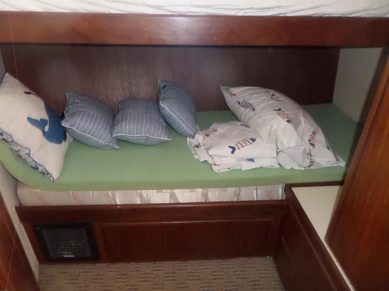 Slide: The Image of Cozy cabin bed with nautical-themed pillows on a 1987 Hatteras 42 Convertible yacht. - 36