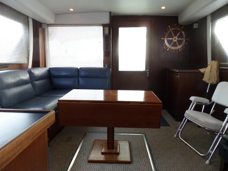 Slide: The Image of Interior of 1987 Hatteras 42 Convertible yacht with blue sofa and wooden table. - 39