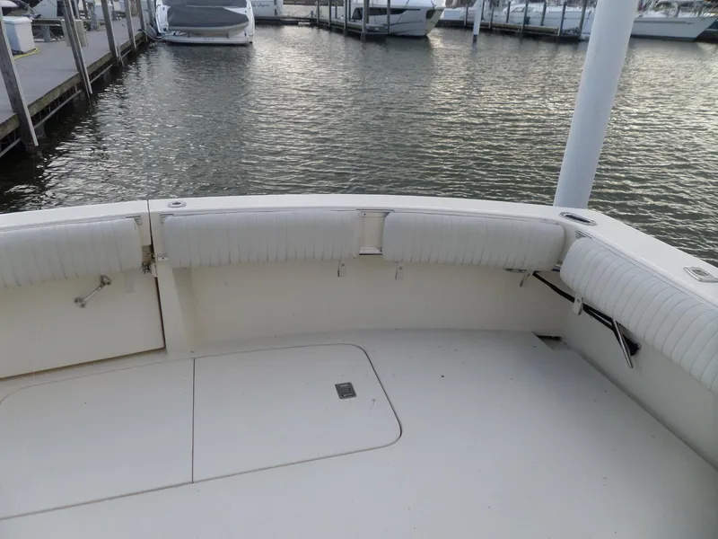 Slide: The Image of 1987 Hatteras 42 Convertible boat deck with white seating, docked at marina. - 7
