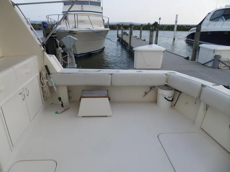 Slide: The Image of 1987 Hatteras 42 Convertible boat interior at dock, featuring spacious seating and storage. - 9