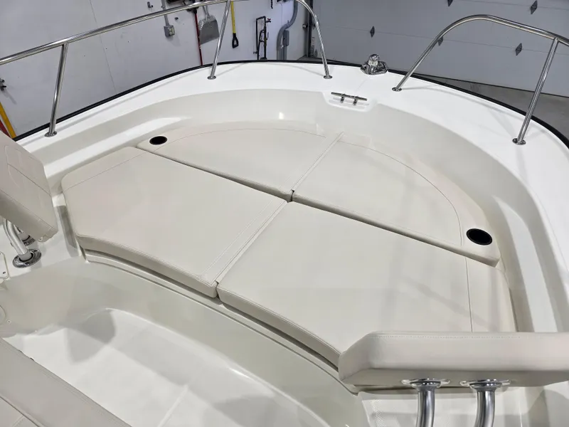 Slide: The Image of 2025 Boston Whaler 210 Montauk boat interior with cushioned seating and stainless steel railings. - 10