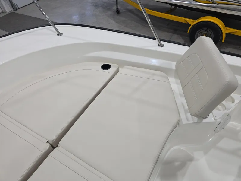 Slide: The Image of 2025 Boston Whaler 210 Montauk boat interior with cushioned seating and cup holders. - 12