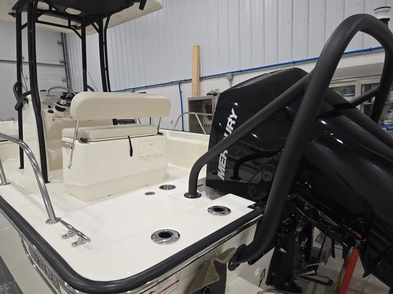 Slide: The Image of 2025 Boston Whaler 210 Montauk boat interior with Mercury engine in a garage setting. - 5