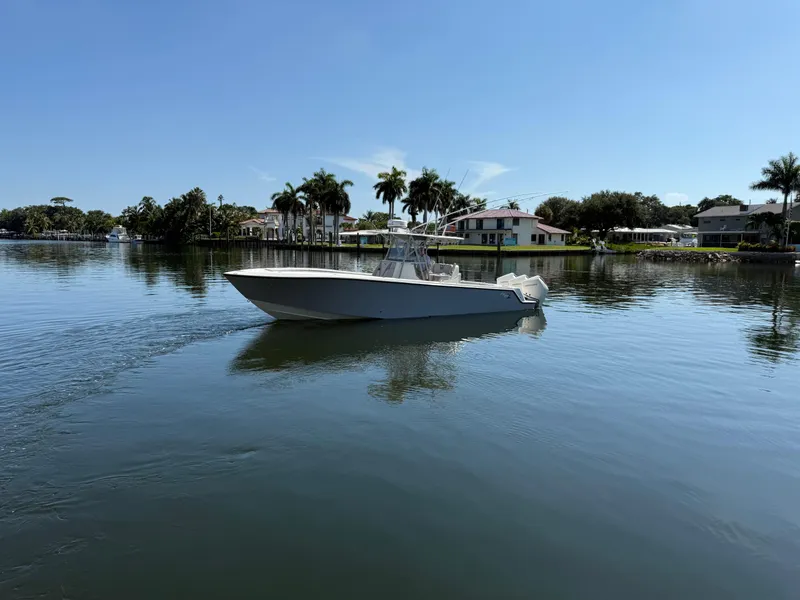 The Image of 2024 SeaVee 340Z boat on calm water with palm trees and houses in the background. - 1
