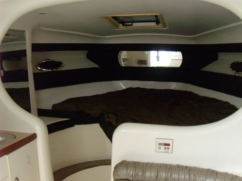 Slide: The Image of Interior cabin of 1996 Silverton 310 Express boat, featuring a cozy sleeping area. - 12