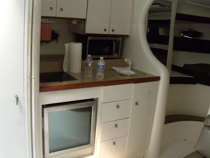Slide: The Image of Interior of 1996 Silverton 310 Express boat with kitchenette and storage cabinets. - 15