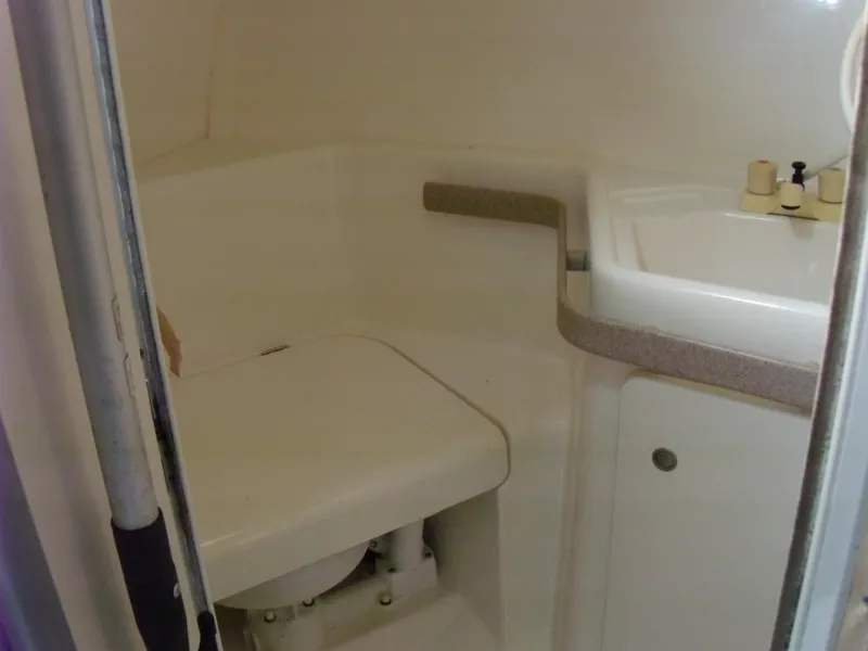 Slide: The Image of 1996 Silverton 310 Express boat bathroom with compact toilet and sink. - 16
