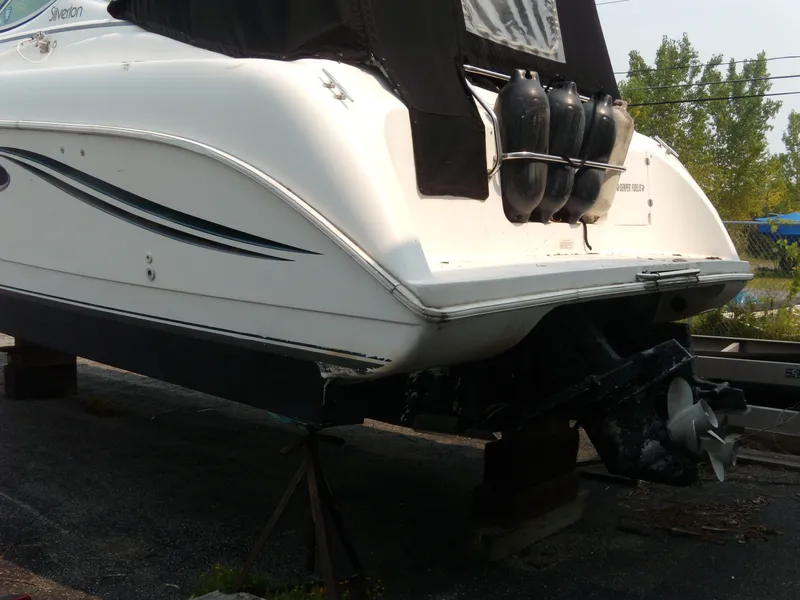 Slide: The Image of 1996 Silverton 310 Express boat on dry dock, rear view with propeller and fenders. - 4