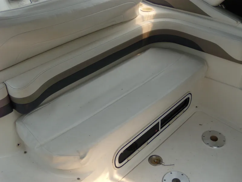 Slide: The Image of 1996 Silverton 310 Express boat interior seating with beige upholstery and cup holders. - 7