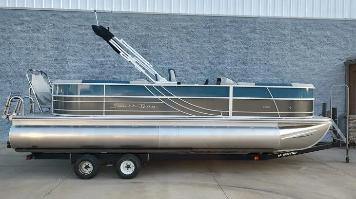 The Image of 2026 South Bay 224RS LE pontoon boat on trailer, parked outdoors. - 1