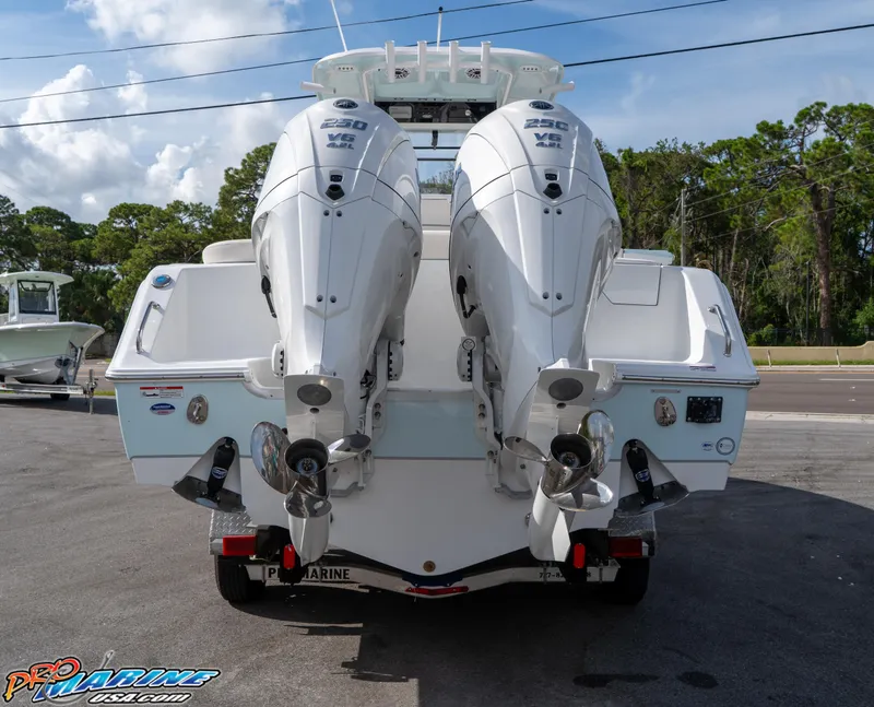 Slide: The Image of 2026 Sea Hunt Ultra 275 SE boat with dual outboard engines, parked on pavement. - 2