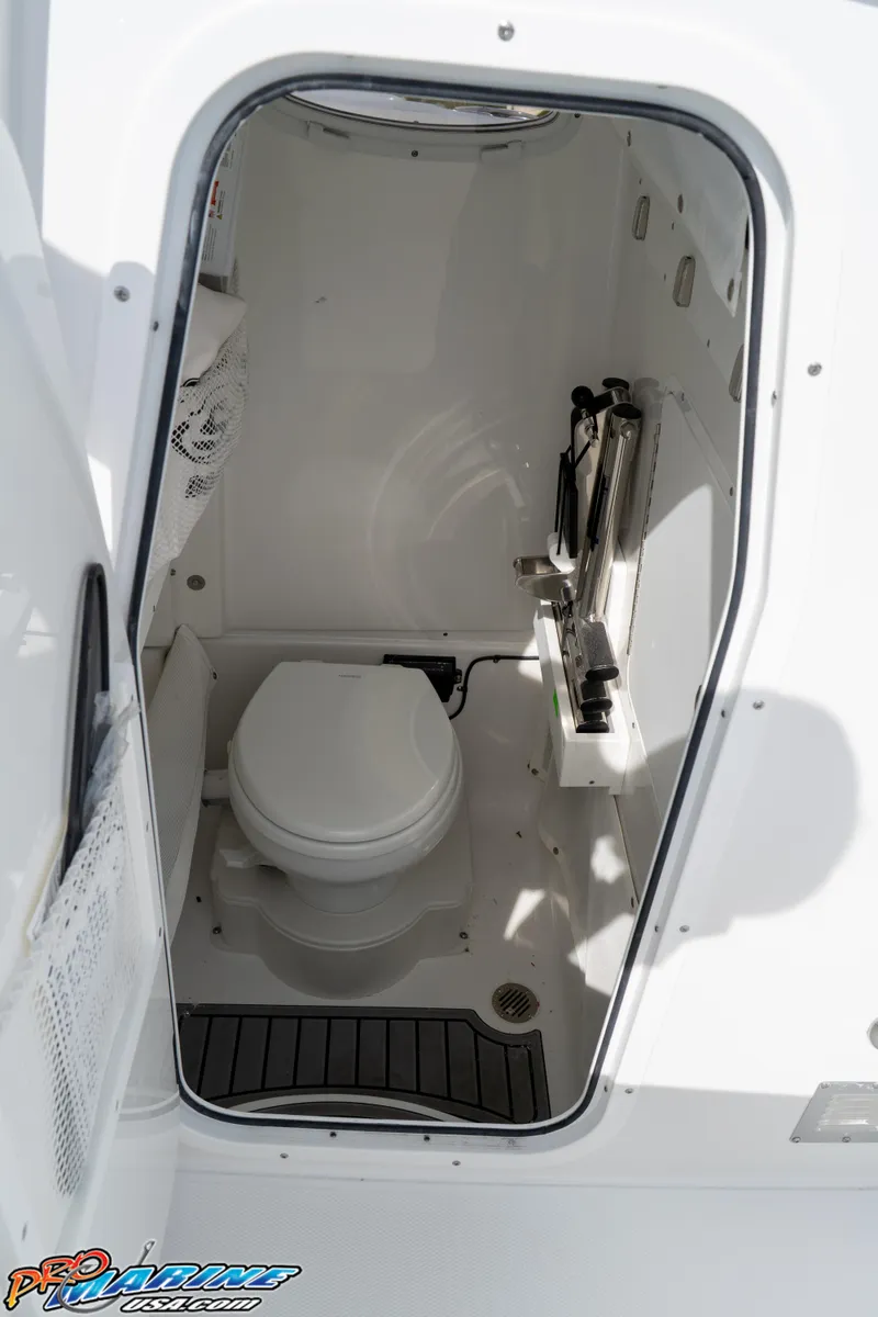 Slide: The Image of 2026 Sea Hunt Ultra 275 SE boat interior with compact marine toilet. - 27