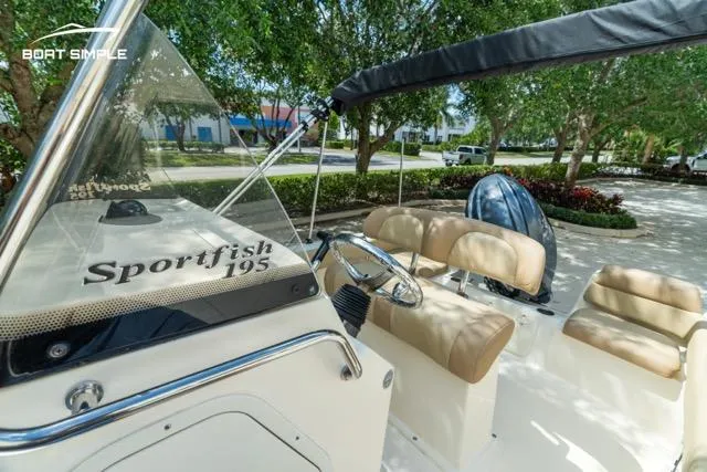 Slide: The Image of 2024 Scout 195 Sportfish boat interior with beige seating and steering wheel. - 6
