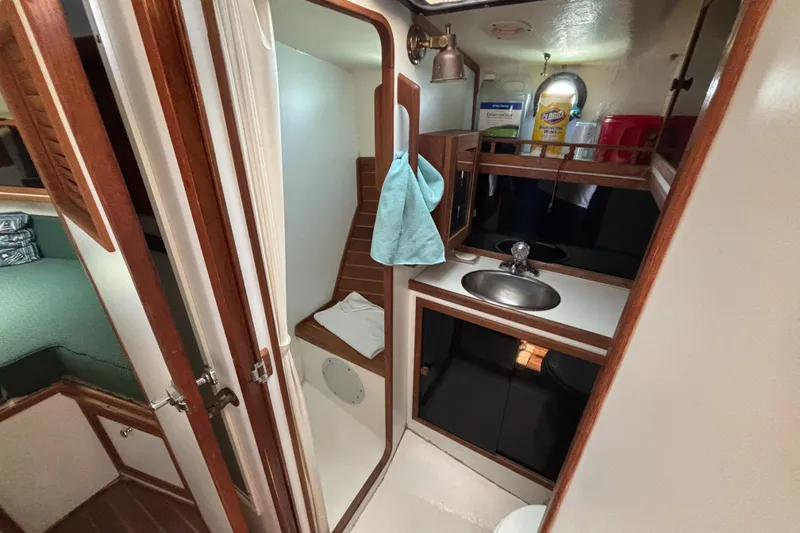 Slide: The Image of Interior of 2000 Eastern Casco Bay 31 boat, featuring compact bathroom and storage area. - 14