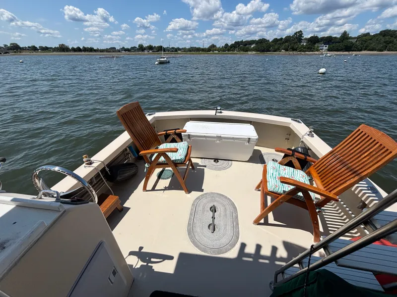 Slide: The Image of Eastern Casco Bay 31 boat deck with chairs and cooler, 2000 model, on a sunny day. - 2