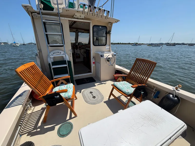 Slide: The Image of Eastern Casco Bay 31 boat deck with chairs, table, and scenic water view. - 3