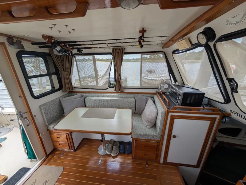 Slide: The Image of Interior of a 2000 Eastern Casco Bay 31 boat with cozy seating and wooden accents. - 7