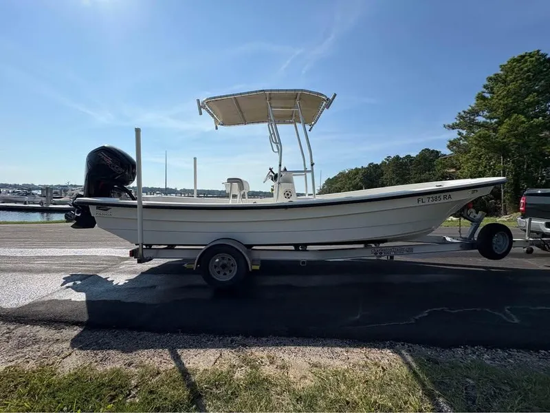 Slide: The Image of 2016 Panga American Panga boat on trailer, parked near marina under clear sky. - 4