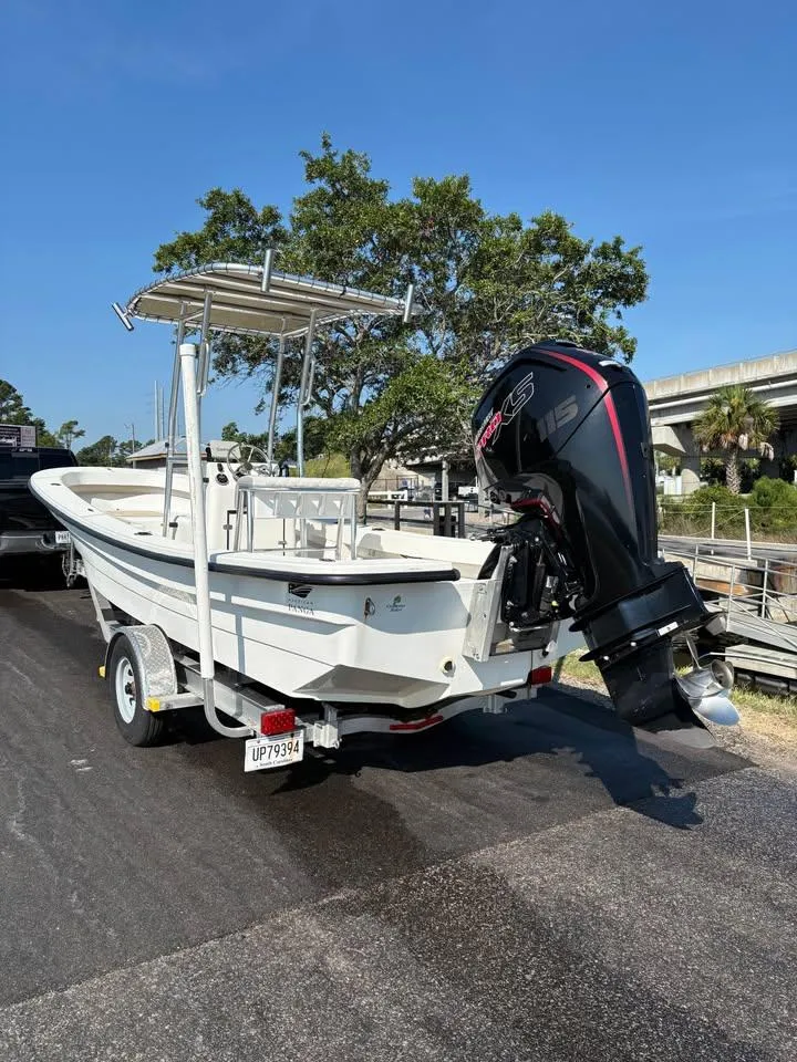 Slide: The Image of 2016 Panga American Panga boat on trailer with outboard motor, parked near waterway. - 5