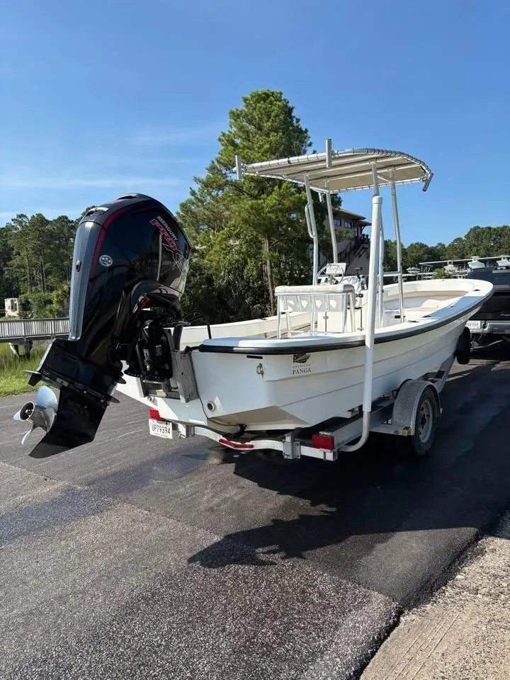 Slide: The Image of 2016 Panga American Panga boat on trailer with outboard motor, parked on a sunny day. - 6