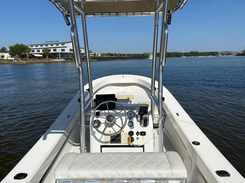 Slide: The Image of 2016 American Panga boat on calm water, featuring steering console and seating. - 8
