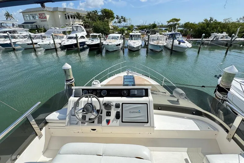 Slide: The Image of 2013 Fairline Squadron 42 yacht helm with marina view, featuring Garmin navigation system. - 30