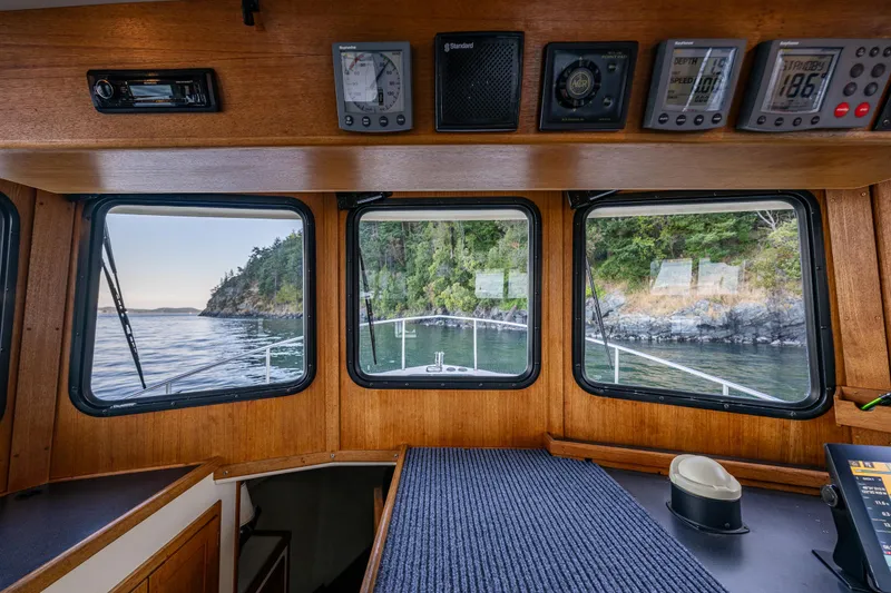 Slide: The Image of Interior view of a 2000 Nordic Tug 32, showcasing navigation instruments and scenic windows. - 13