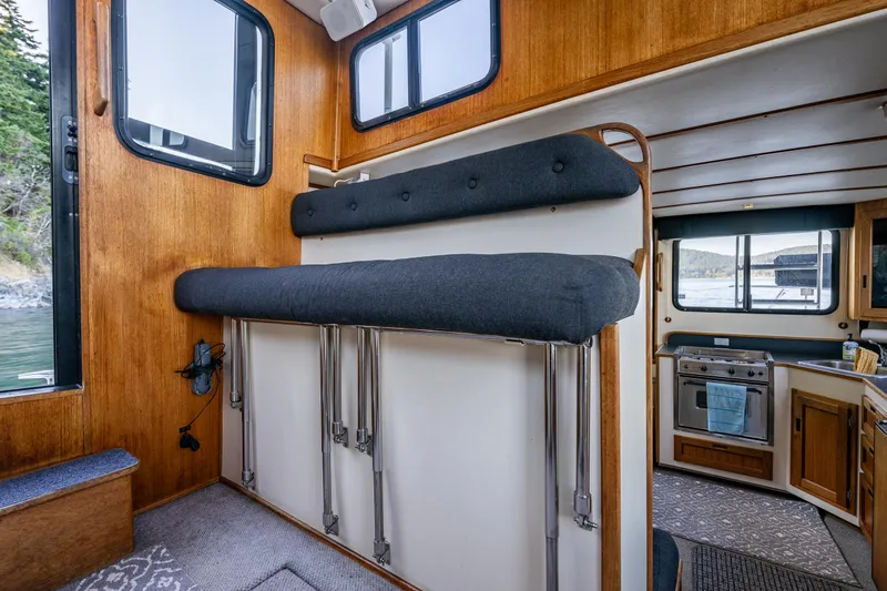 Slide: The Image of Interior of a 2000 Nordic Tug 32 boat with wooden paneling and compact kitchen. - 16