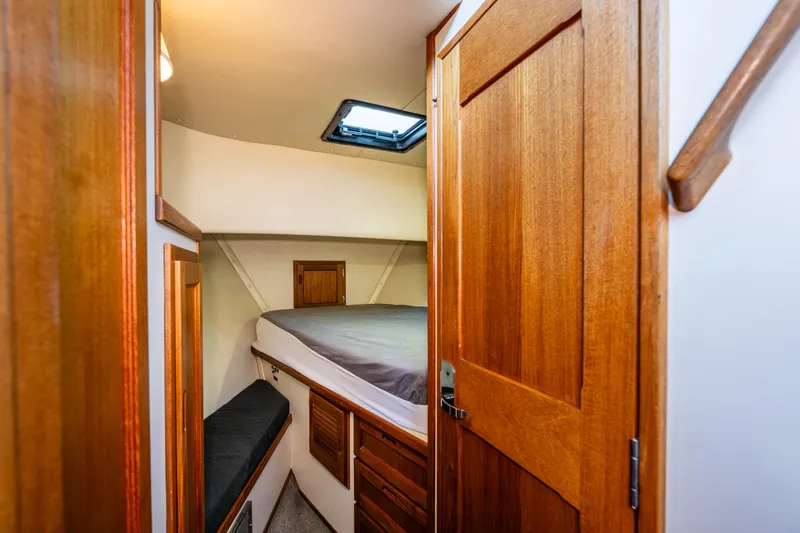 Slide: The Image of Cozy cabin interior of 2000 Nordic Tug 32 with wooden door and bed. - 18
