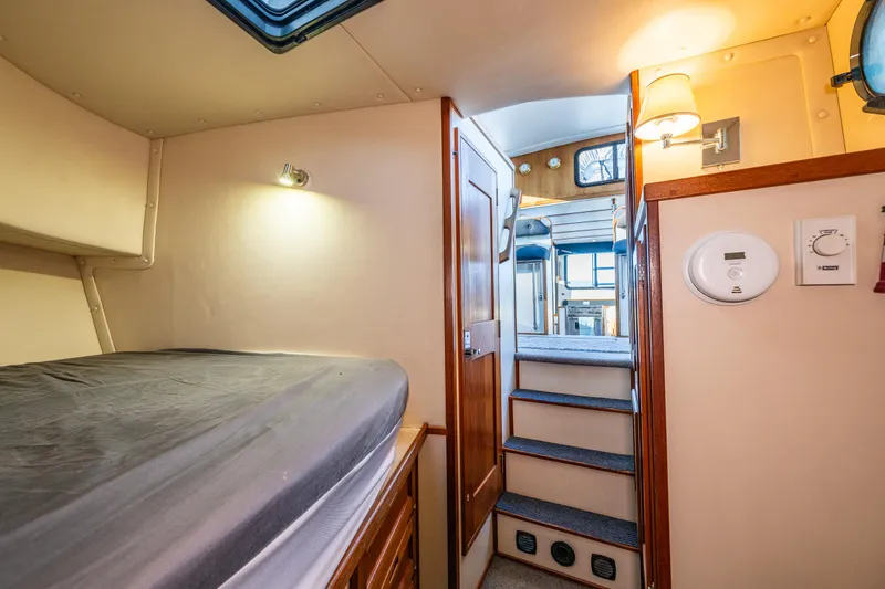Slide: The Image of Cozy cabin interior of 2000 Nordic Tug 32 with bed, stairs, and wooden accents. - 19