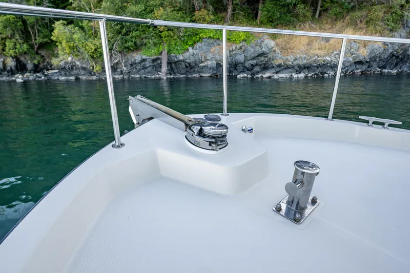 Slide: The Image of Nordic Tug 32 boat deck with railing, near rocky shoreline, 2000 model. - 30
