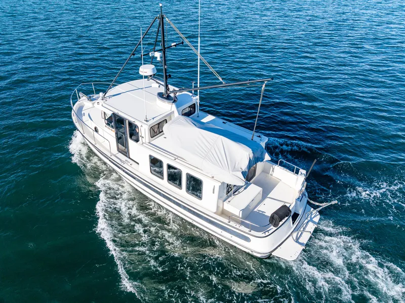 Slide: The Image of Nordic Tug 32, 2000 model, cruising on open water, aerial view. - 32