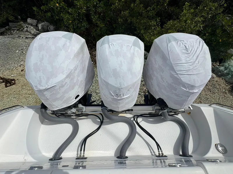 Slide: The Image of Triple outboard motors covered, Everglades 355 Tournament boat, 2016 model, docked near foliage. - 28