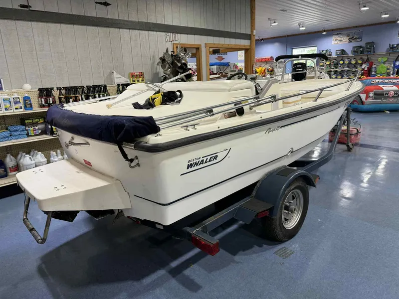 Slide: The Image of 1997 Boston Whaler Rage 15 boat on trailer in showroom setting. - 14
