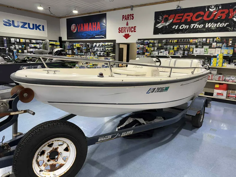 Slide: The Image of 1997 Boston Whaler Rage 15 boat displayed in a showroom with Yamaha and Suzuki signage. - 17
