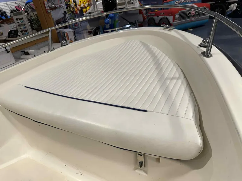 Slide: The Image of 1997 Boston Whaler Rage 15 boat interior with white cushioned seating. - 6